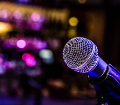 Microphone set up with lights for a comedy music show in a bar.